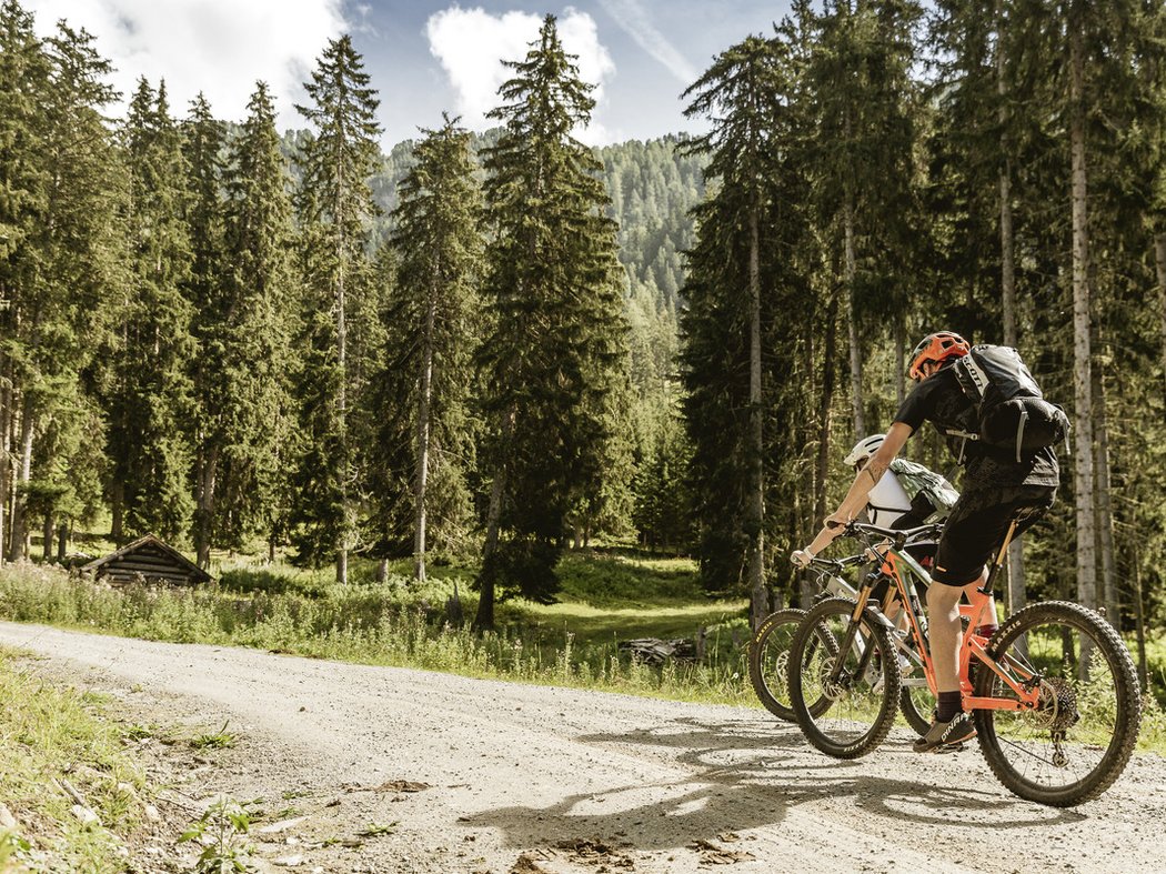 Bike Hotel Post Prutz Zwei Mountainbiker fahren auf einem Waldweg im Gebirge