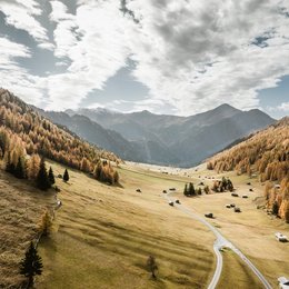 Ihr Wohlfühlort: das Hotel in Prutz im Tiroler Oberland ⛰️ Herbstliche Berglandschaft mit Tal, Nadelbäumen und verstreuten Hütten