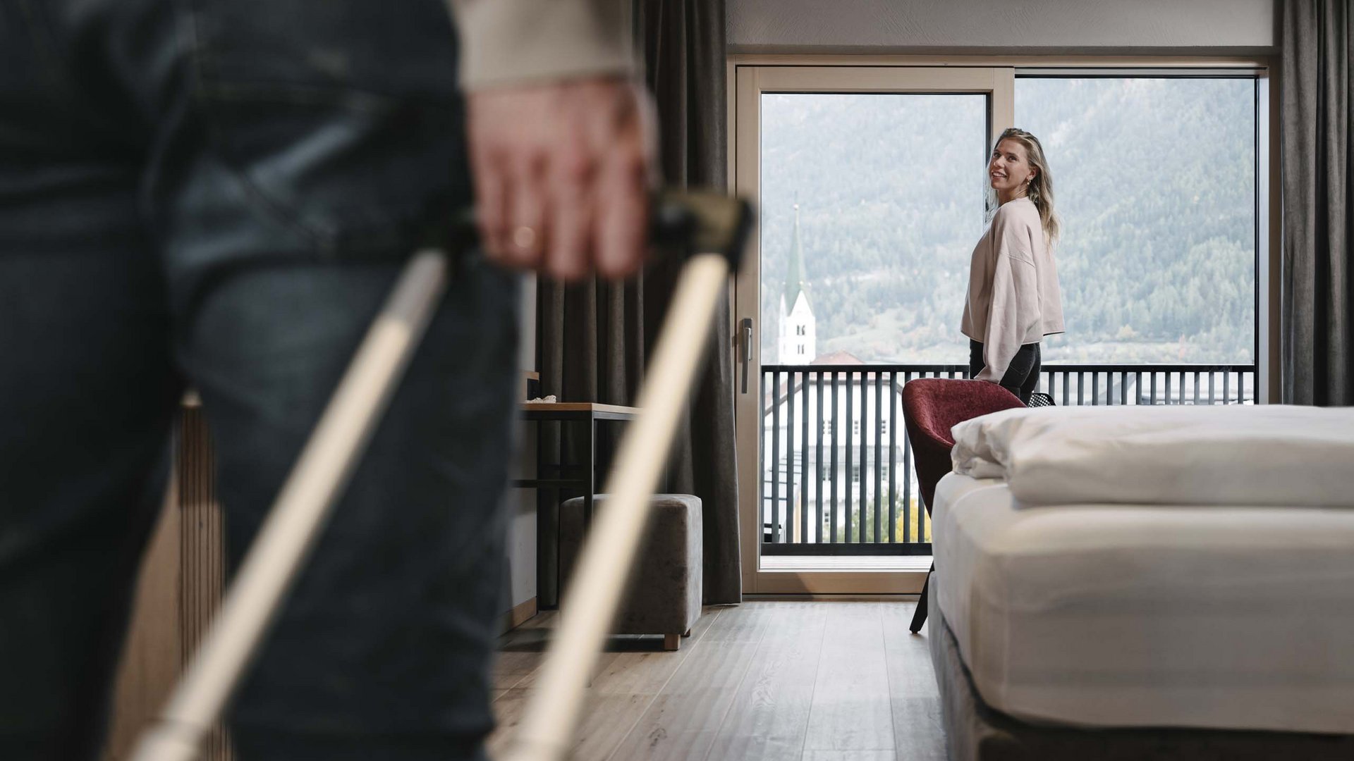 Looking for a hotel in Prutz? Person with suitcase entering hotel room, woman looking out window at mountains