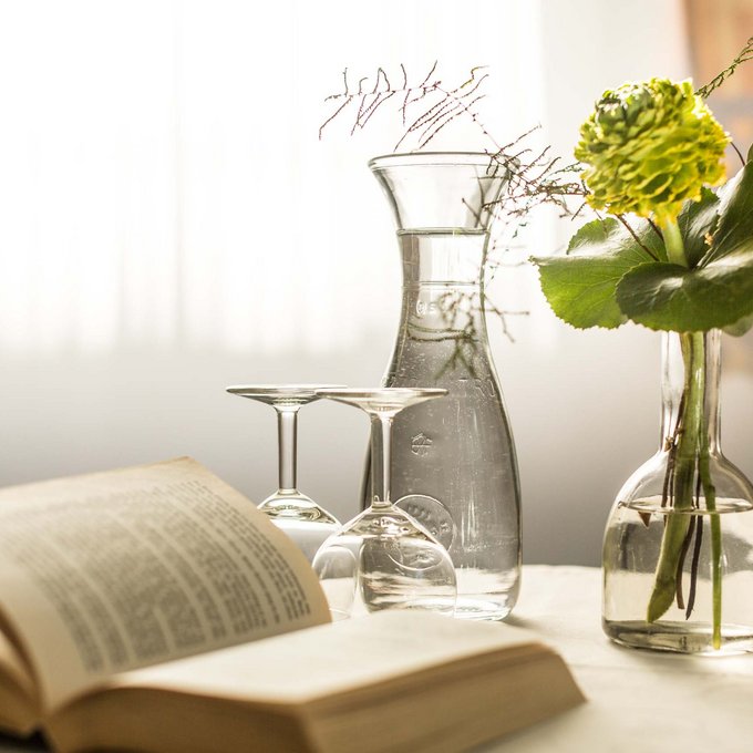 Your accommodation in Prutz Open book, two wine glasses, carafe and flowers in vase on bright table